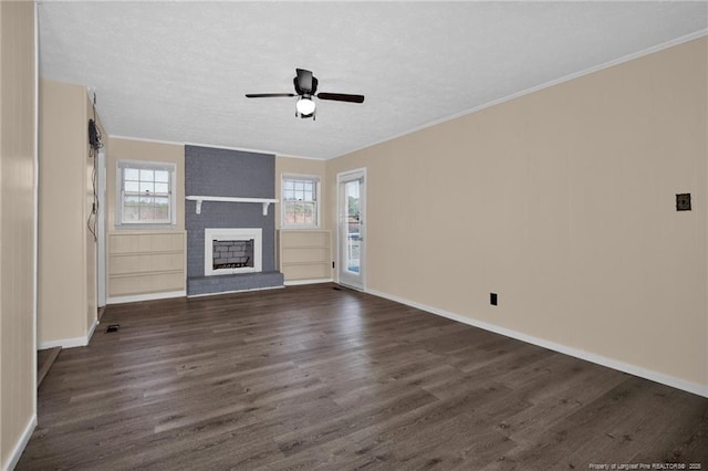 unfurnished living room featuring crown molding, dark wood-type flooring, a fireplace, and ceiling fan