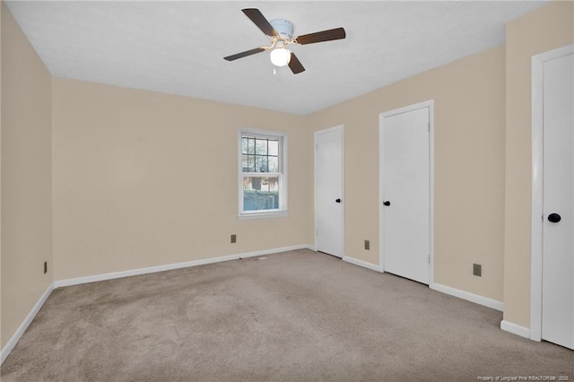 carpeted spare room with ceiling fan