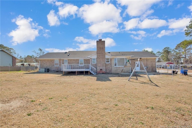 rear view of property with a wooden deck and a lawn