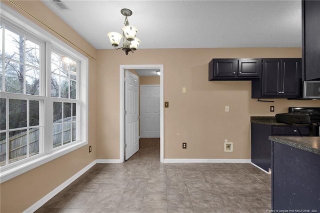 kitchen featuring an inviting chandelier, hanging light fixtures, and range