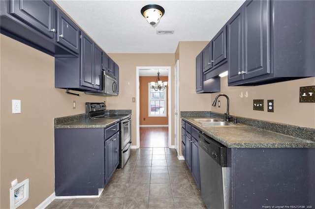 kitchen with sink, a chandelier, tile patterned flooring, stainless steel appliances, and blue cabinetry