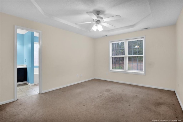 carpeted empty room with ceiling fan and a textured ceiling