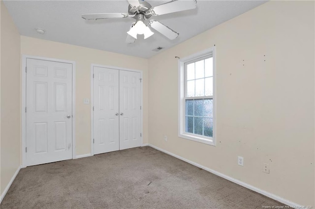 unfurnished bedroom with light carpet, ceiling fan, and a closet