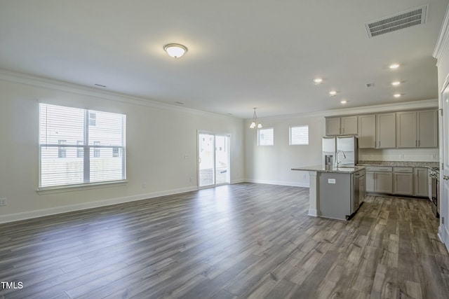 kitchen featuring crown molding, dark hardwood / wood-style floors, gray cabinets, pendant lighting, and a kitchen island with sink