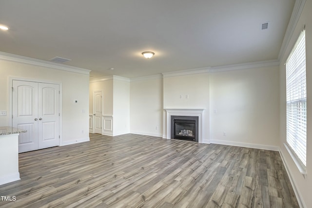 unfurnished living room featuring crown molding and hardwood / wood-style flooring