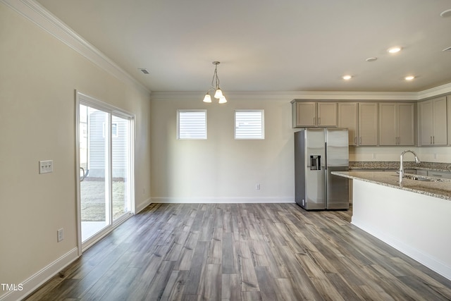 kitchen featuring sink, ornamental molding, stainless steel fridge, gray cabinets, and light stone countertops