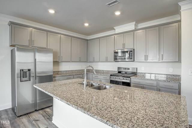 kitchen featuring sink, light hardwood / wood-style flooring, stainless steel appliances, light stone counters, and ornamental molding