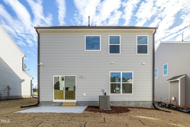 rear view of house with central AC unit, a yard, and a patio area