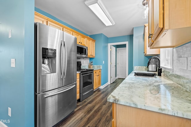 kitchen with light brown cabinets, a sink, baseboards, appliances with stainless steel finishes, and dark wood finished floors