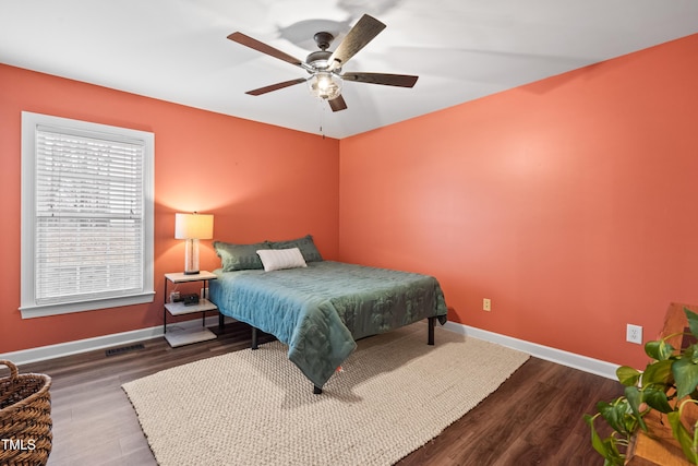 bedroom with dark wood-style flooring, visible vents, and baseboards