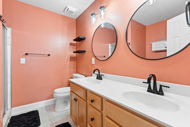 bathroom featuring toilet, a sink, visible vents, and baseboards