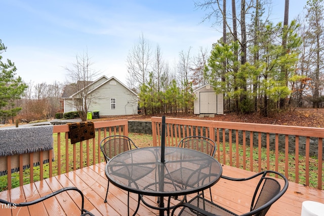 wooden deck featuring a storage shed, an outdoor structure, and outdoor dining space