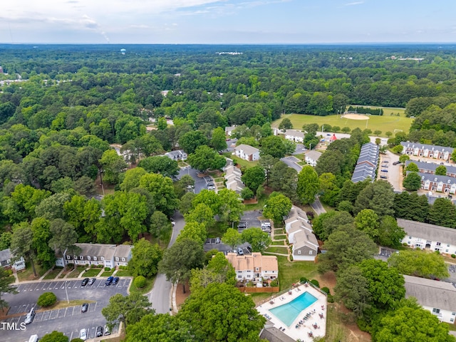 drone / aerial view of a forest and a pool area