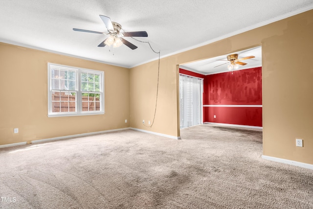 spare room with ceiling fan, carpet flooring, crown molding, baseboards, and a textured ceiling