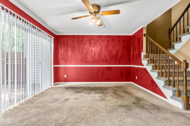 unfurnished room featuring carpet floors, ceiling fan, stairway, and ornamental molding