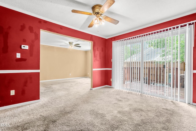 unfurnished room featuring ceiling fan, carpet, baseboards, ornamental molding, and a textured ceiling