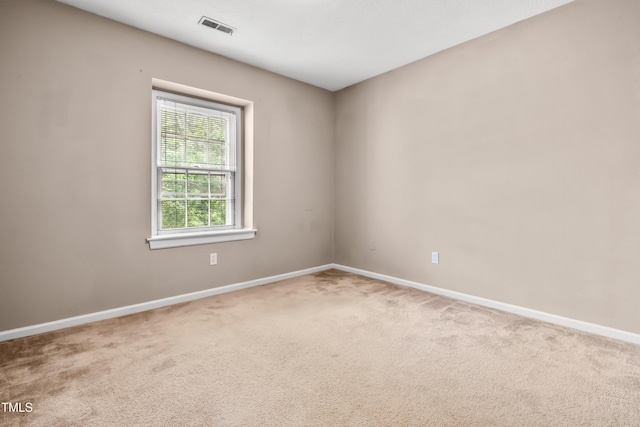 unfurnished room featuring carpet and baseboards