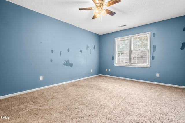 carpeted spare room with a ceiling fan and baseboards