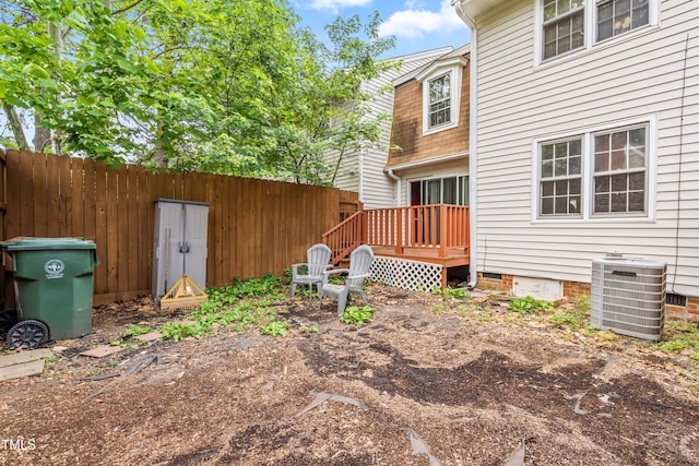 rear view of house featuring cooling unit, fence, crawl space, and a wooden deck