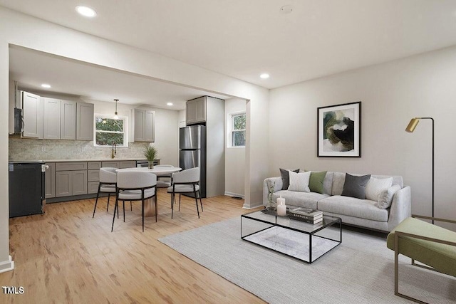 living room featuring sink and light hardwood / wood-style flooring