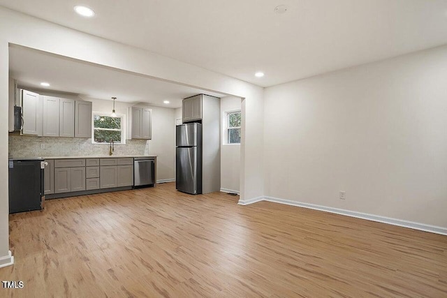 kitchen featuring stainless steel appliances, sink, hanging light fixtures, and gray cabinetry