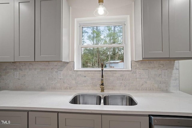 kitchen with sink, gray cabinetry, black dishwasher, tasteful backsplash, and decorative light fixtures