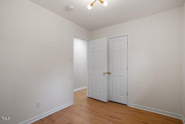 unfurnished bedroom with a closet and light wood-type flooring