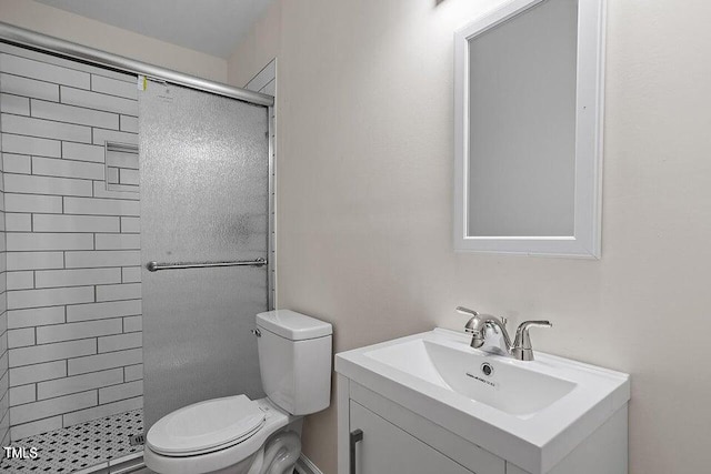 bathroom with vanity, a tile shower, and toilet