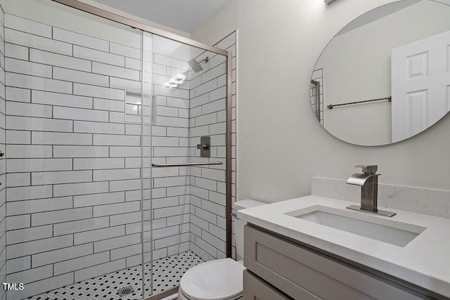 bathroom with vanity, a shower with shower door, and toilet