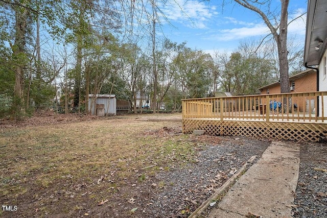 view of yard featuring a wooden deck and a storage unit