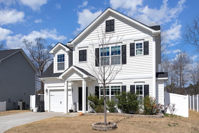 traditional-style house with driveway, a garage, and fence