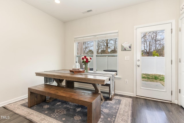 dining space with dark wood finished floors, baseboards, and a wealth of natural light