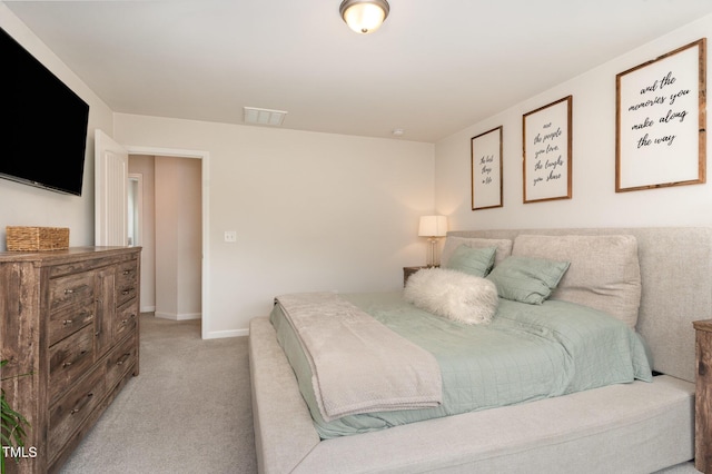 bedroom with visible vents, light carpet, and baseboards