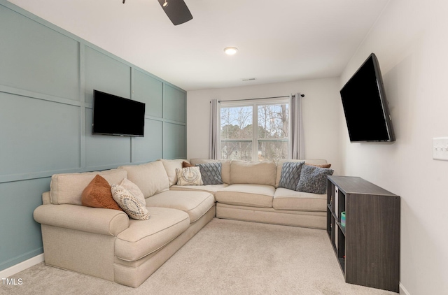 carpeted living room featuring a ceiling fan and baseboards