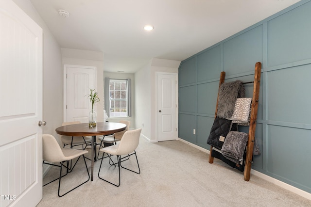 dining space featuring recessed lighting, baseboards, light carpet, and a decorative wall