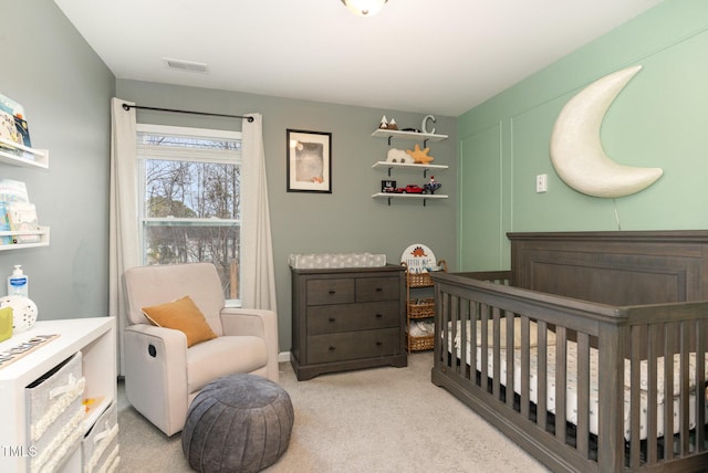 bedroom with light carpet, visible vents, and a nursery area