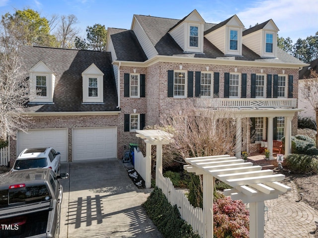 view of front of home with roof with shingles, fence, concrete driveway, and brick siding