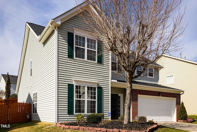 traditional home with a garage, concrete driveway, brick siding, and fence