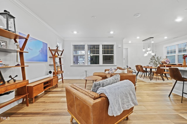 living room featuring crown molding, plenty of natural light, and light wood-type flooring