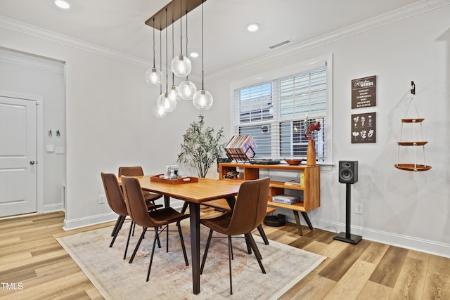 dining room featuring crown molding and light hardwood / wood-style floors