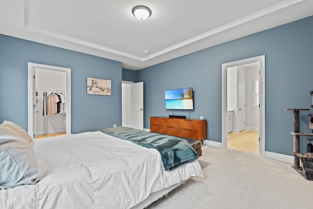 bedroom featuring ensuite bath and light carpet