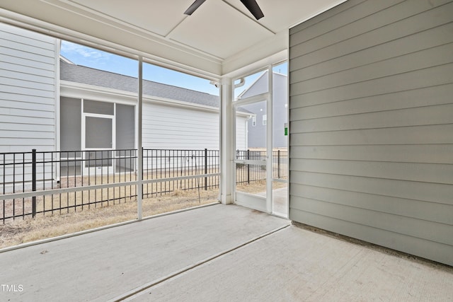 unfurnished sunroom featuring ceiling fan and plenty of natural light