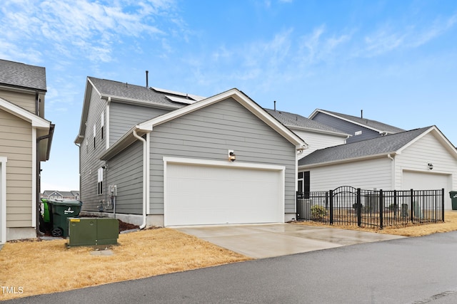 view of front of property with cooling unit, a garage, and solar panels