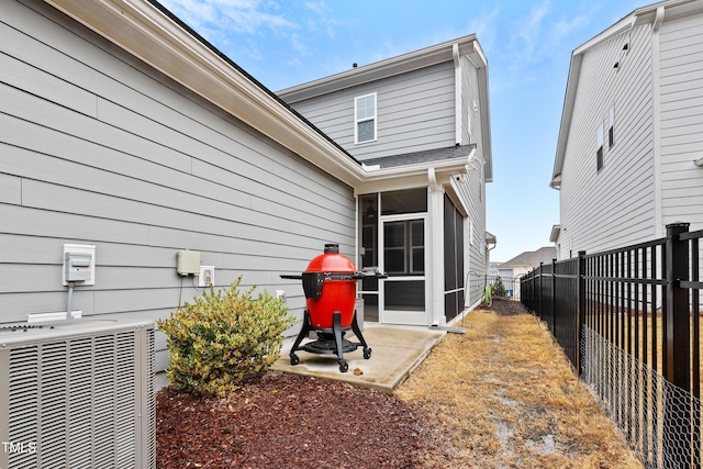 rear view of house with central AC, a sunroom, and a patio