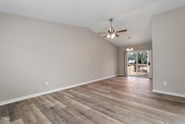 spare room with wood-type flooring, vaulted ceiling, and ceiling fan with notable chandelier