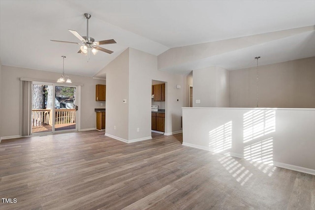 unfurnished room with lofted ceiling, hardwood / wood-style flooring, and ceiling fan with notable chandelier