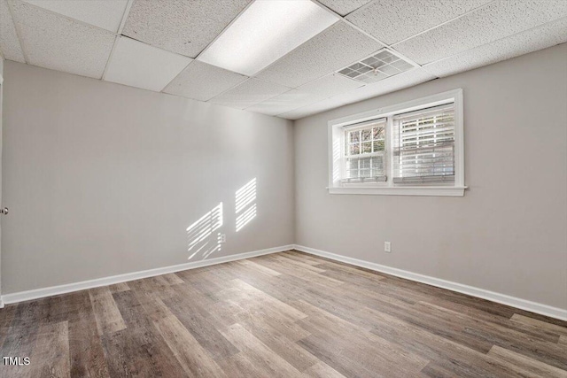 spare room featuring a paneled ceiling and hardwood / wood-style floors