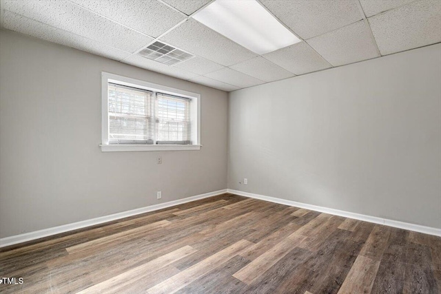 unfurnished room featuring hardwood / wood-style floors and a paneled ceiling