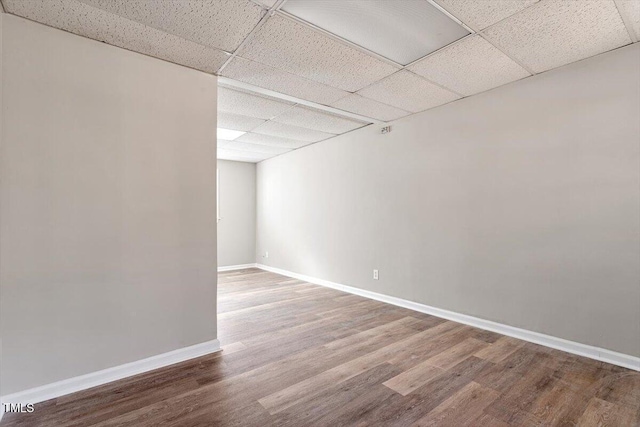 spare room with wood-type flooring and a drop ceiling