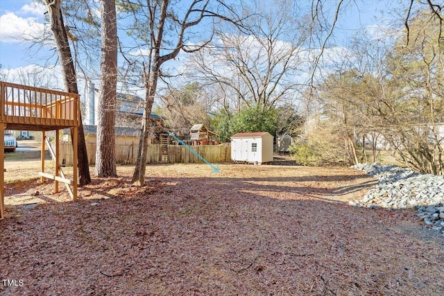 view of yard with a playground, a deck, and a shed